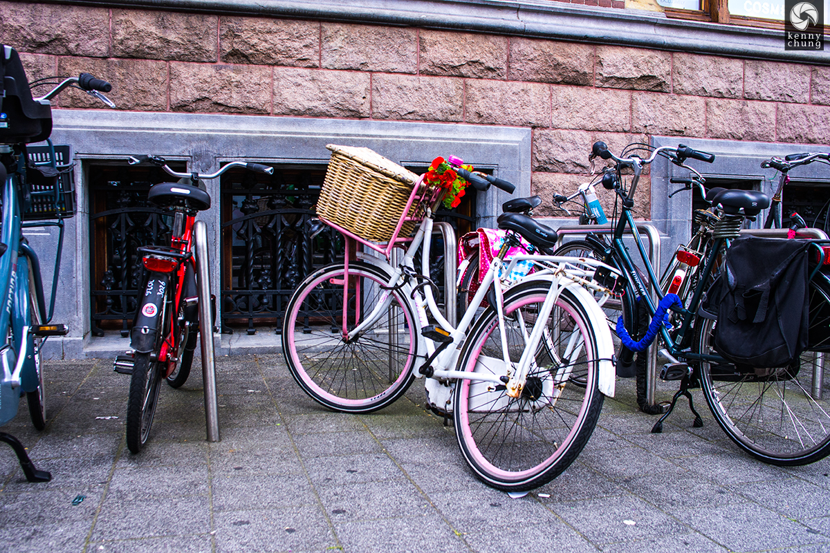 A pink bike with flowers attached on the streets of Amsterdam