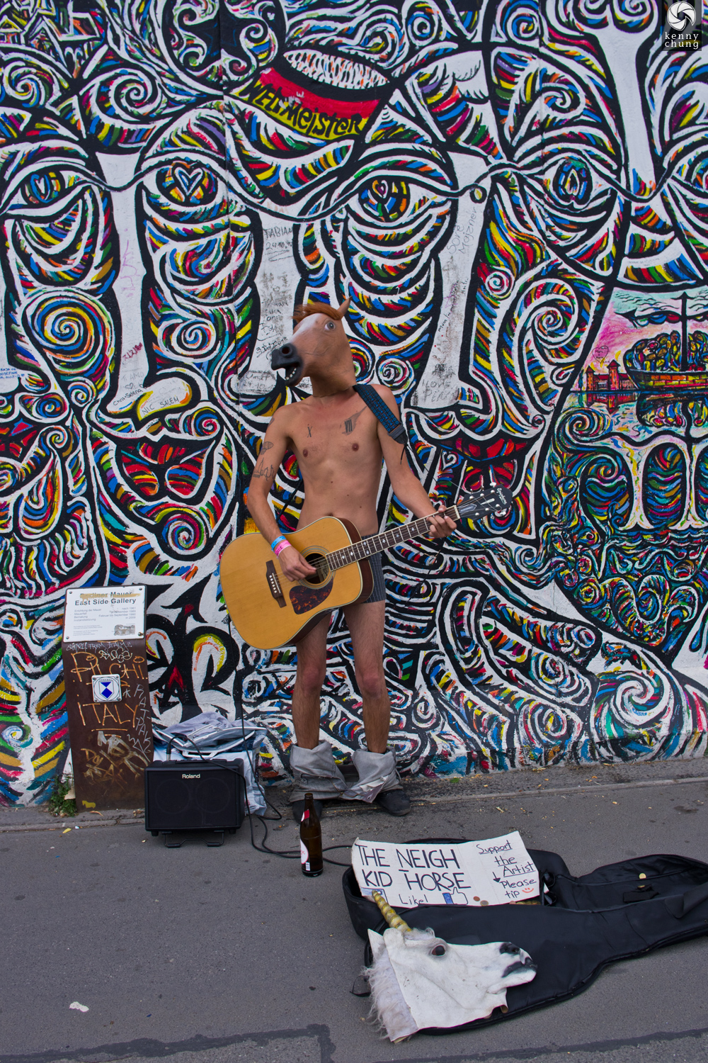 Street guitarist in a horse mask performing in front of Worlds People by Schamil Gimajev