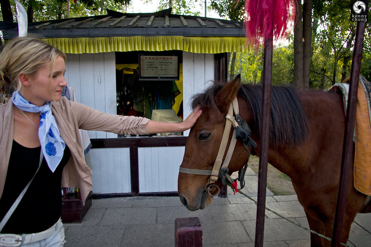 Girl petting horse in Three Kingdoms City