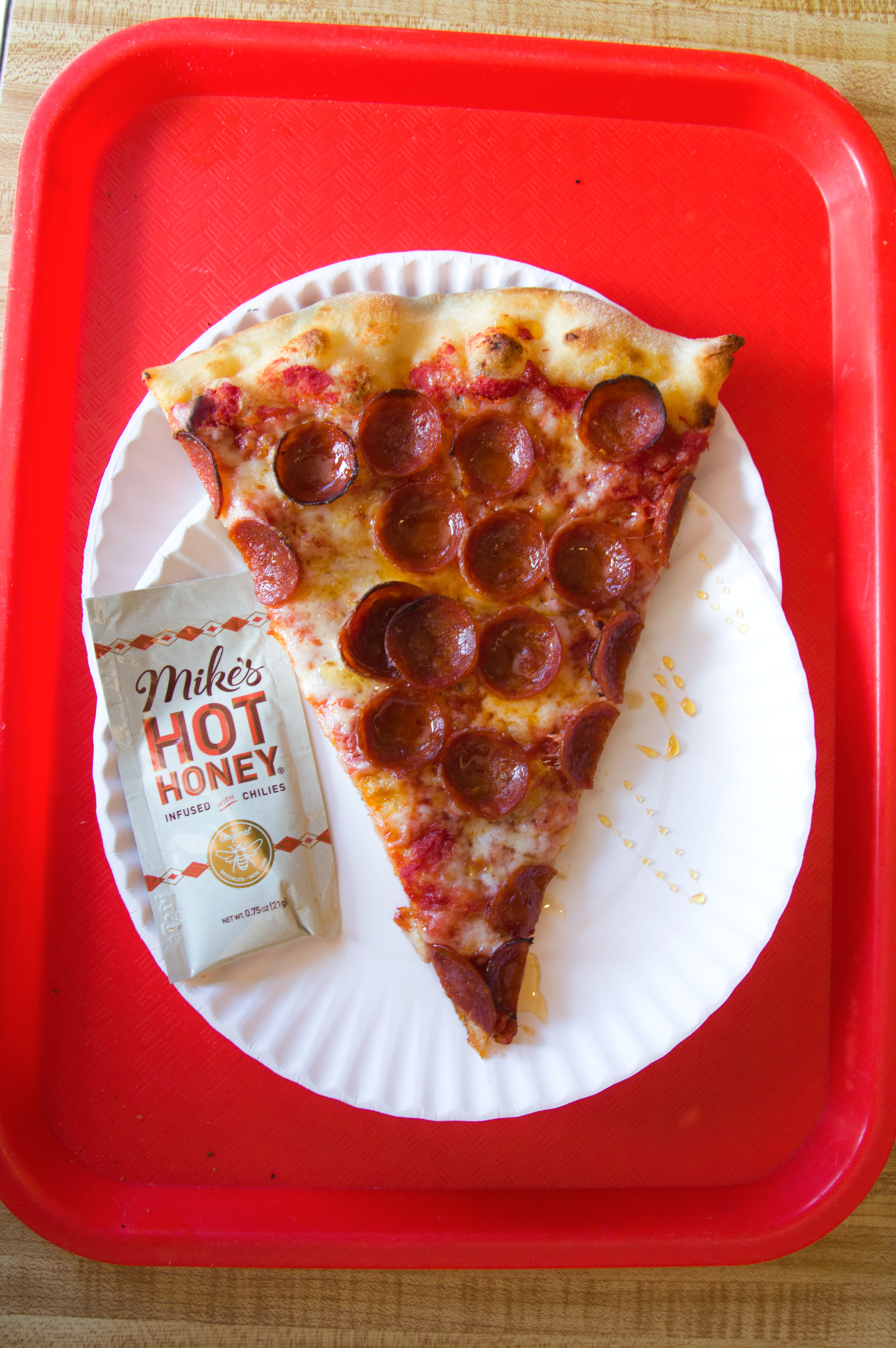 A slice of pepperoni pizza with Mikes Hot Honey at Paulie Gee's Slice Shop