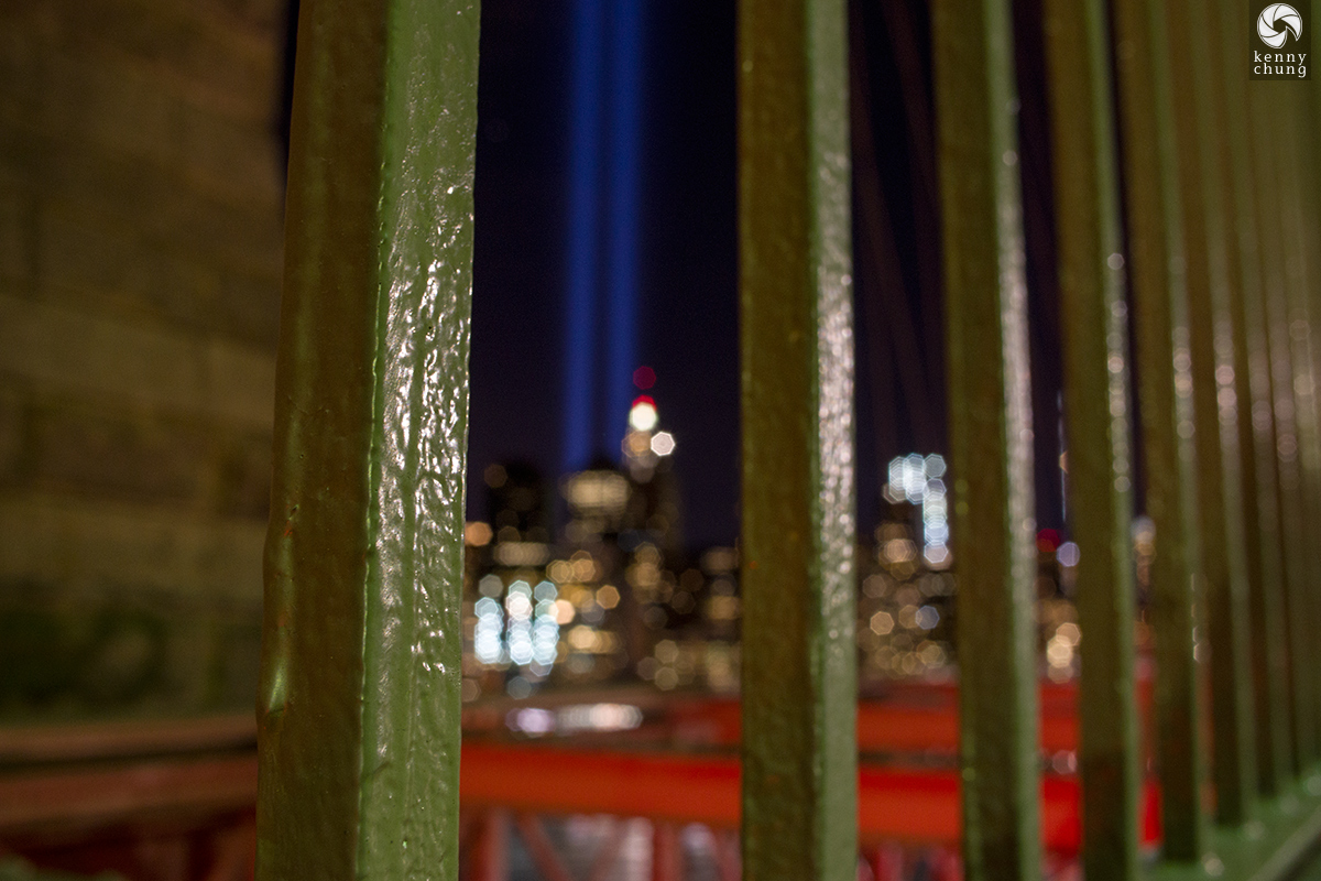 Tribute in Light through the Brooklyn Bridge fence